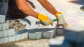 Construction worker laying paver blocks
