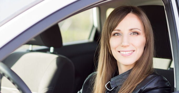Young woman behind the wheel of her car